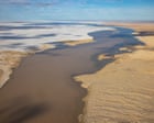 Flood waters pour into Kati Thanda-Lake Eyre in rare spectacle ‘supercharged by climate change’